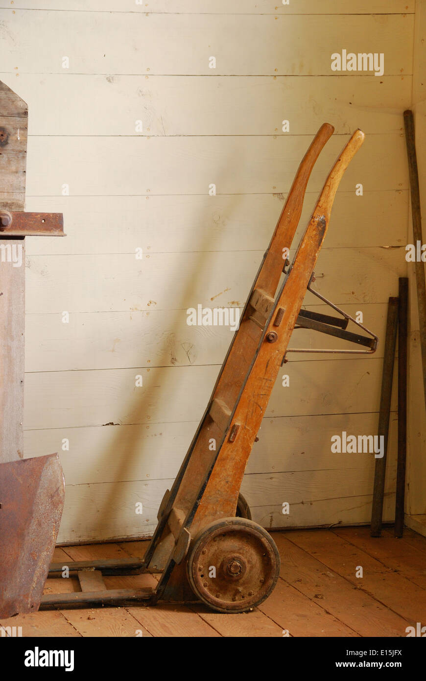 alte Sack Handwagen gegen eine Wand in einem alten Gebäude der Landwirtschaft Stockfoto