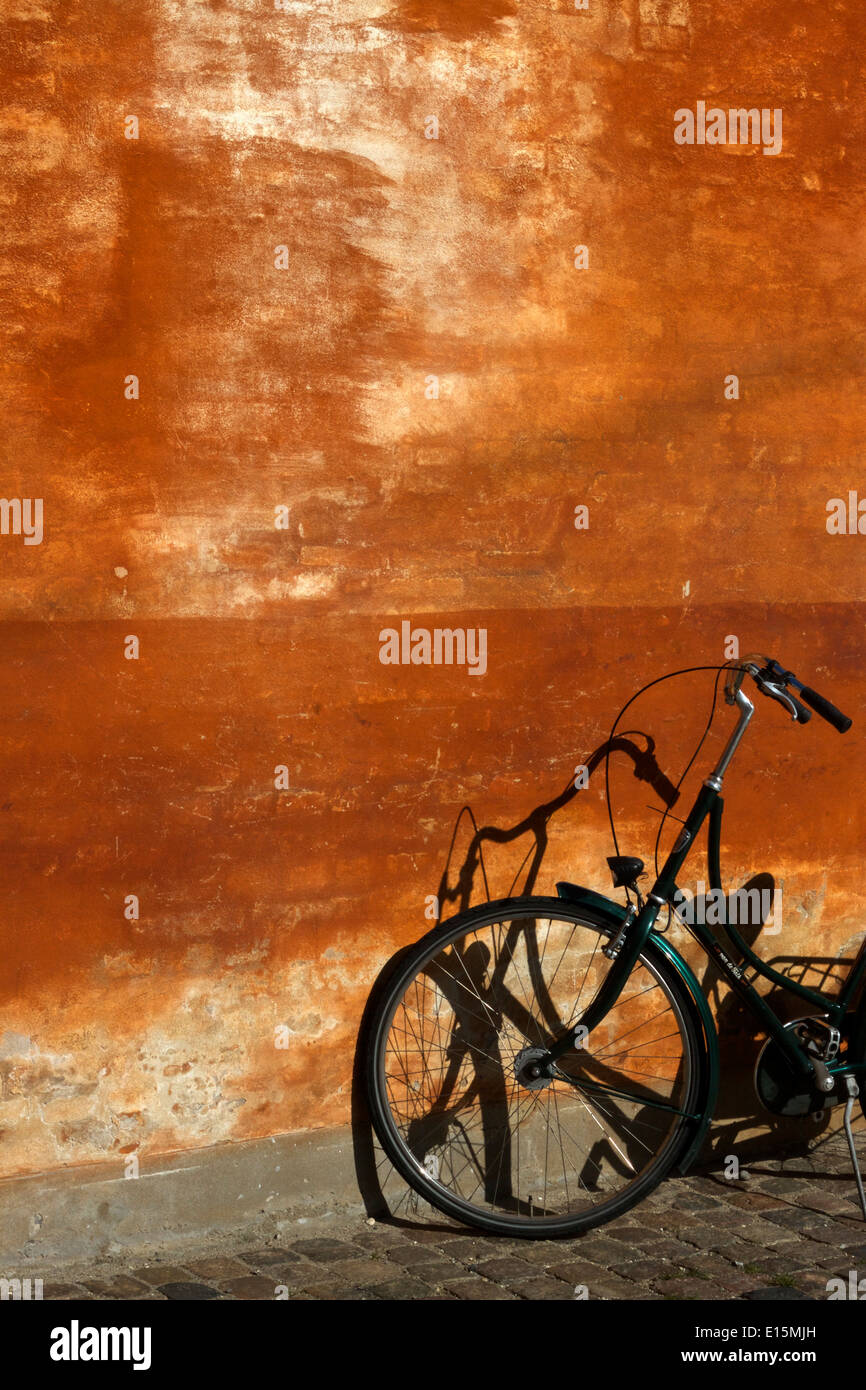 Fahrrad und Schatten gegen Ess-Wand in Kopenhagen Stockfoto