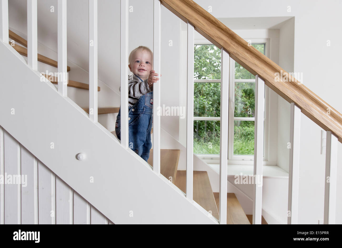 Junge, 1 Jahr, die Treppe hinauf klettern Stockfoto