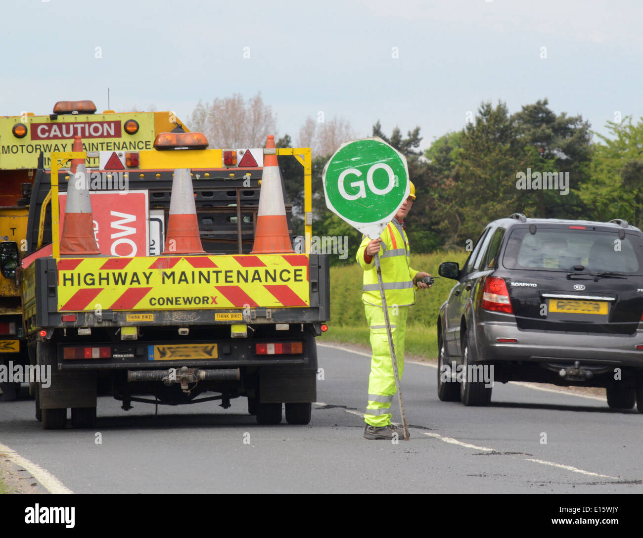 Bauarbeiter mit Lollipop Stop - Go Zeichen zur Steuerung von Datenverkehr auf Baustellen Vereinigtes Königreich Stockfoto
