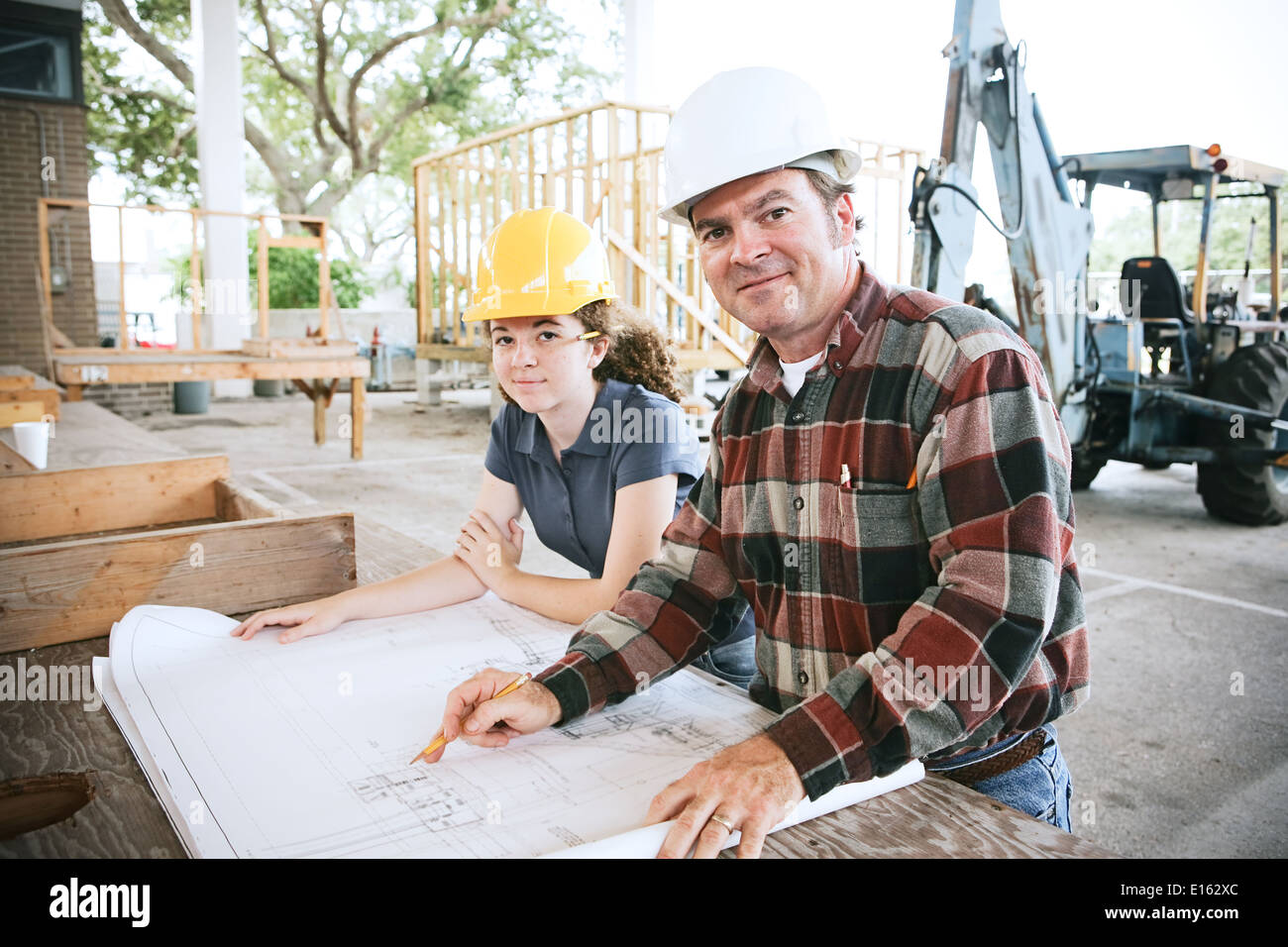 Ingenieur gehen über Baupläne mit einer Studentin auf der Baustelle. Stockfoto