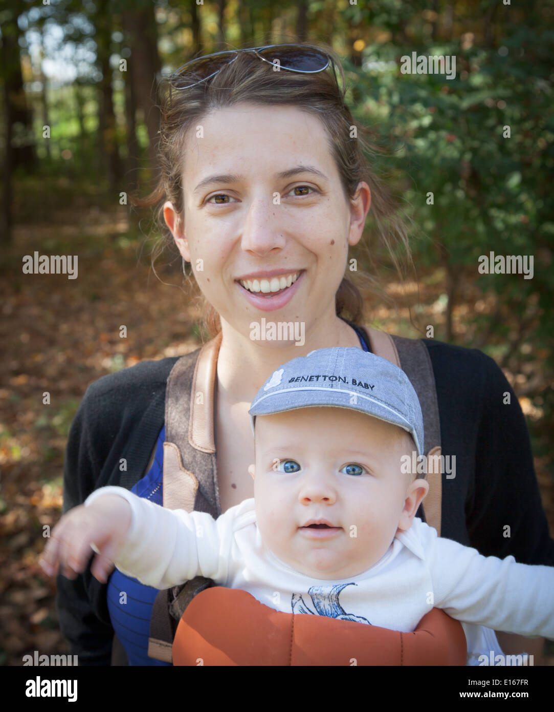 Frau trägt ihr Baby junge in einem Park und lächelnd Stockfoto