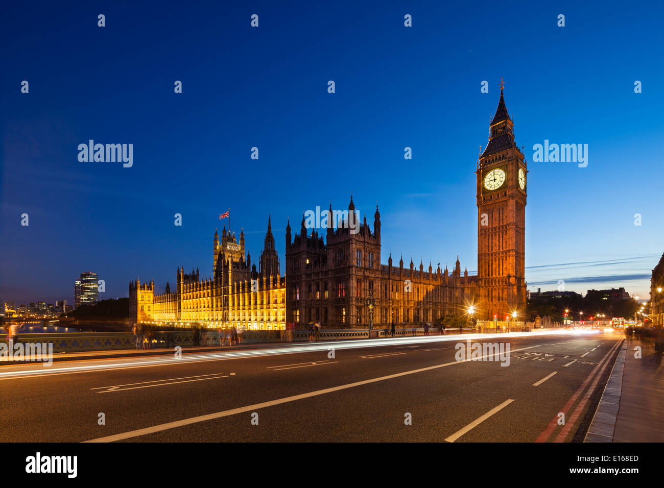 Langzeitbelichtung Nachtaufnahme von den Houses of Parliament in London mit blauen Himmel und die Westminster Bridge im Vordergrund. Stockfoto