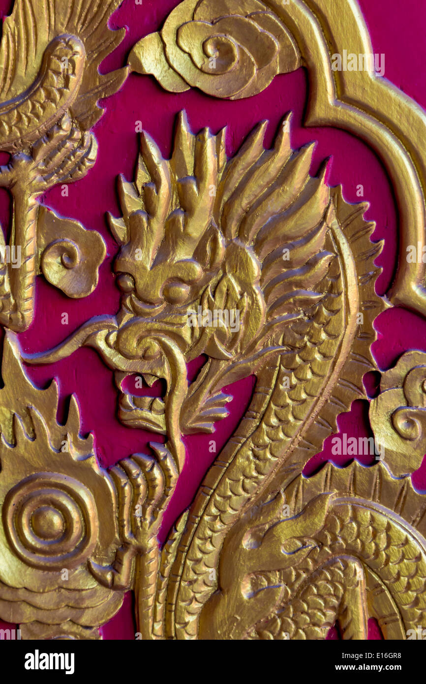 Golden Dragon Head auf rote Holztür Stockfoto