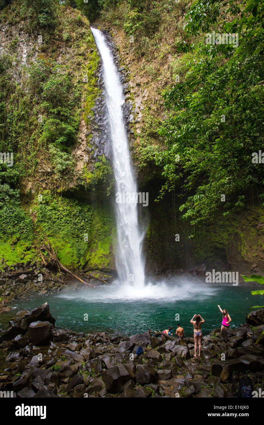 Badegäste durch das Tauchbecken La Fortuna Wasserfall oder Catarata Fortuna in der Nähe von Arenal Vulkan im Norden von Costa Rica Stockfoto