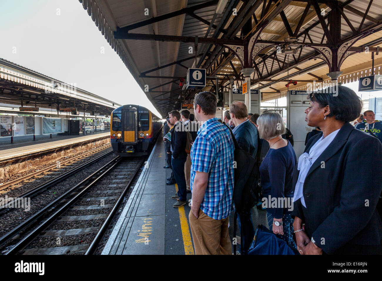 Pendler, die warten auf einen Zug, Bahnhof Clapham Junction, London, England Stockfoto