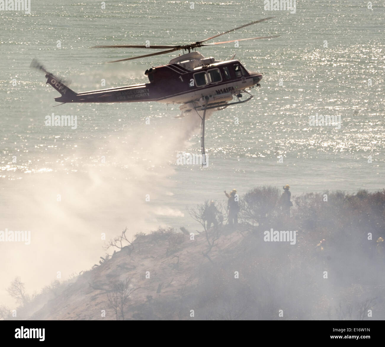 San Onofre, Kalifornien, USA. 14. Mai 2014. Eine Orange County Fire Authority Wasser fallen Bell UH-1 Super Huey Hubschrauber kämpft das Pendleton West Autobahn Feuer im San Onofre State Park in Kalifornien auf Mittwoch, 14. Mai 2014. Eine Camp Pendleton Marine Base Feuer kämpfen Hand Besatzung stehen als die OCFA Hubschrauber Aids in das Feuer im Blick auf den Pazifischen Ozean am Mittwoch Nachmittag aufwischen. © David Bro/ZUMAPRESS.com/Alamy Live-Nachrichten Stockfoto San Onofre, Kalifornien, USA. 14. Mai 2014. Eine Orange County Fire Authority Wasser fallen Bell UH-1 Super Huey Hubschrauber kämpft das Pendleton West Autobahn Feuer im San Onofre State Park in Kalifornien auf Mittwoch, 14. Mai 2014. Eine Camp Pendleton Marine Base Feuer kämpfen Hand Besatzung stehen als die OCFA Hubschrauber Aids in das Feuer im Blick auf den Pazifischen Ozean am Mittwoch Nachmittag aufwischen. © David Bro/ZUMAPRESS.com/Alamy Live-Nachrichten Stockfoto