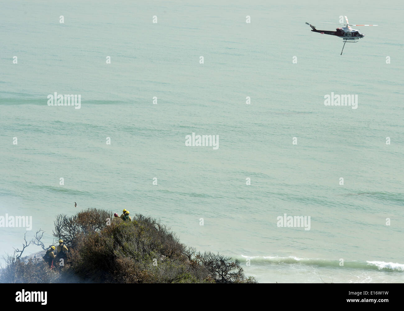 San Onofre, Kalifornien, USA. 14. Mai 2014. Eine Orange County Fire Authority Wasser fallen Bell UH-1 Super Huey Hubschrauber kämpft das Pendleton West Autobahn Feuer im San Onofre State Park in Kalifornien auf Mittwoch, 14. Mai 2014. Eine Camp Pendleton Marine Base Feuer kämpfen Hand Besatzung stehen als die OCFA Hubschrauber Aids in das Feuer im Blick auf den Pazifischen Ozean am Mittwoch Nachmittag aufwischen. © David Bro/ZUMAPRESS.com/Alamy Live-Nachrichten Stockfoto San Onofre, Kalifornien, USA. 14. Mai 2014. Eine Orange County Fire Authority Wasser fallen Bell UH-1 Super Huey Hubschrauber kämpft das Pendleton West Autobahn Feuer im San Onofre State Park in Kalifornien auf Mittwoch, 14. Mai 2014. Eine Camp Pendleton Marine Base Feuer kämpfen Hand Besatzung stehen als die OCFA Hubschrauber Aids in das Feuer im Blick auf den Pazifischen Ozean am Mittwoch Nachmittag aufwischen. © David Bro/ZUMAPRESS.com/Alamy Live-Nachrichten Stockfoto