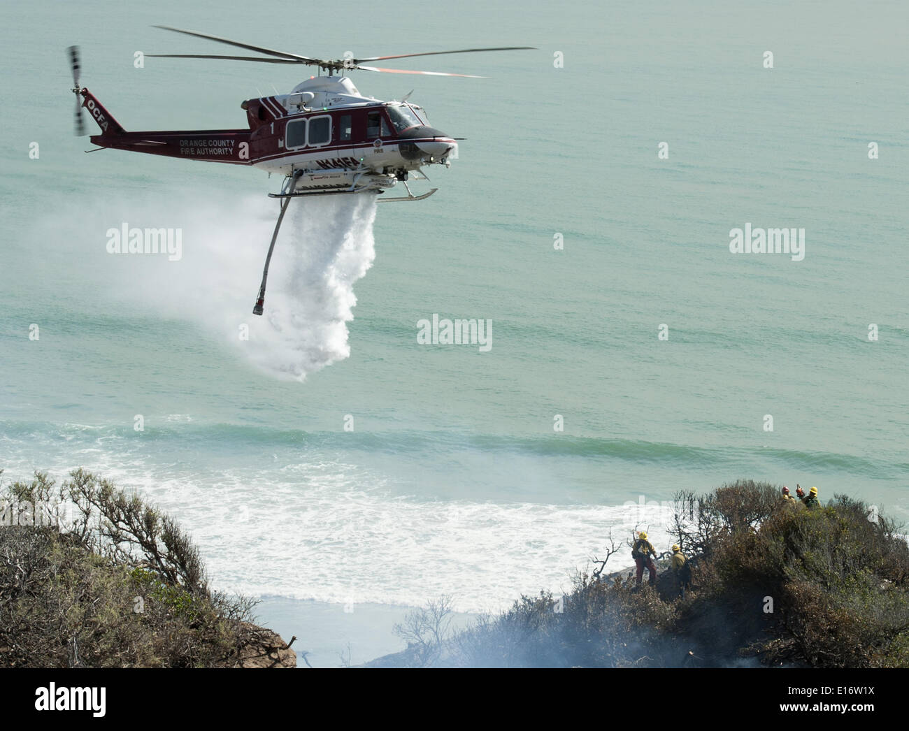San Onofre, Kalifornien, USA. 14. Mai 2014. Eine Orange County Fire Authority Wasser fallen Bell UH-1 Super Huey Hubschrauber kämpft das Pendleton West Autobahn Feuer im San Onofre State Park in Kalifornien auf Mittwoch, 14. Mai 2014. Eine Camp Pendleton Marine Base Feuer kämpfen Hand Besatzung stehen als die OCFA Hubschrauber Aids in das Feuer im Blick auf den Pazifischen Ozean am Mittwoch Nachmittag aufwischen. © David Bro/ZUMAPRESS.com/Alamy Live-Nachrichten Stockfoto San Onofre, Kalifornien, USA. 14. Mai 2014. Eine Orange County Fire Authority Wasser fallen Bell UH-1 Super Huey Hubschrauber kämpft das Pendleton West Autobahn Feuer im San Onofre State Park in Kalifornien auf Mittwoch, 14. Mai 2014. Eine Camp Pendleton Marine Base Feuer kämpfen Hand Besatzung stehen als die OCFA Hubschrauber Aids in das Feuer im Blick auf den Pazifischen Ozean am Mittwoch Nachmittag aufwischen. © David Bro/ZUMAPRESS.com/Alamy Live-Nachrichten Stockfoto