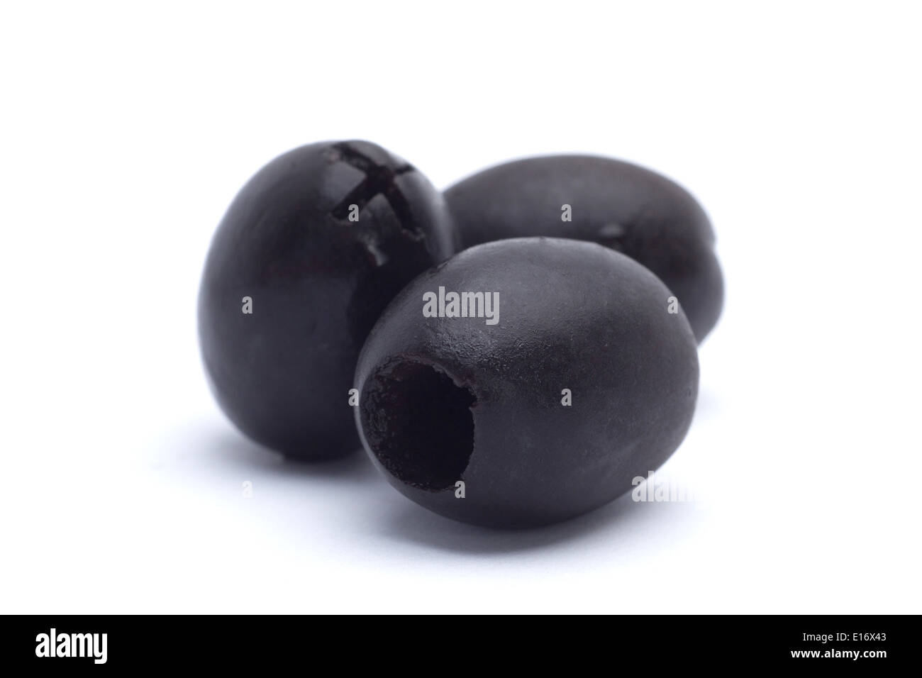 Marinierte schwarze entsteinte Oliven Closeup isoliert auf weißem Hintergrund Stockfoto