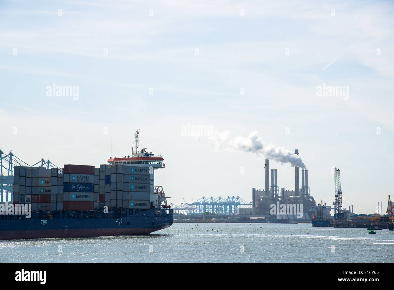 Containerschiff mit Fracht und Powerstation im Hintergrund Stockfoto