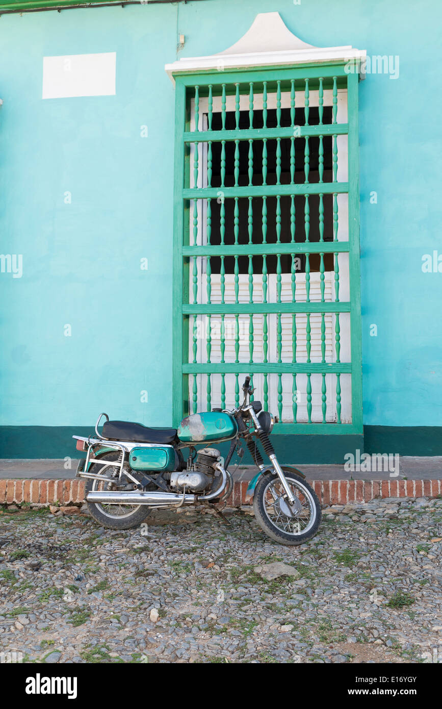 Altes Motorrad vor einer Wand mit Fenster, Trinidad, Kuba Stockfoto