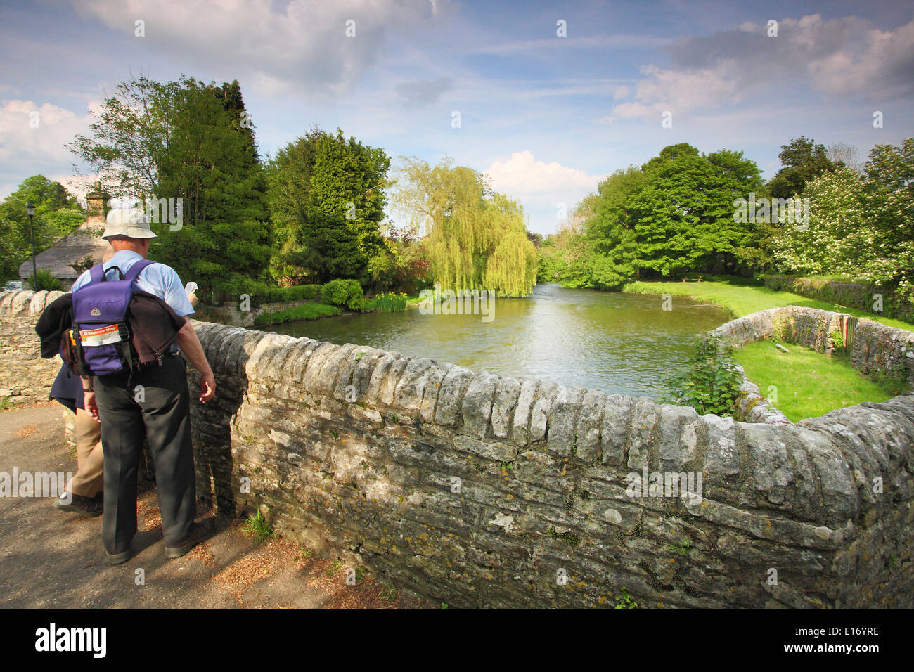 Wanderer innehalten und eine Karte auf die mittelalterliche Brücke über den Fluss Wye bei Ashford-in-the-Water, Peak District, England, UK - Mai zu studieren Stockfoto