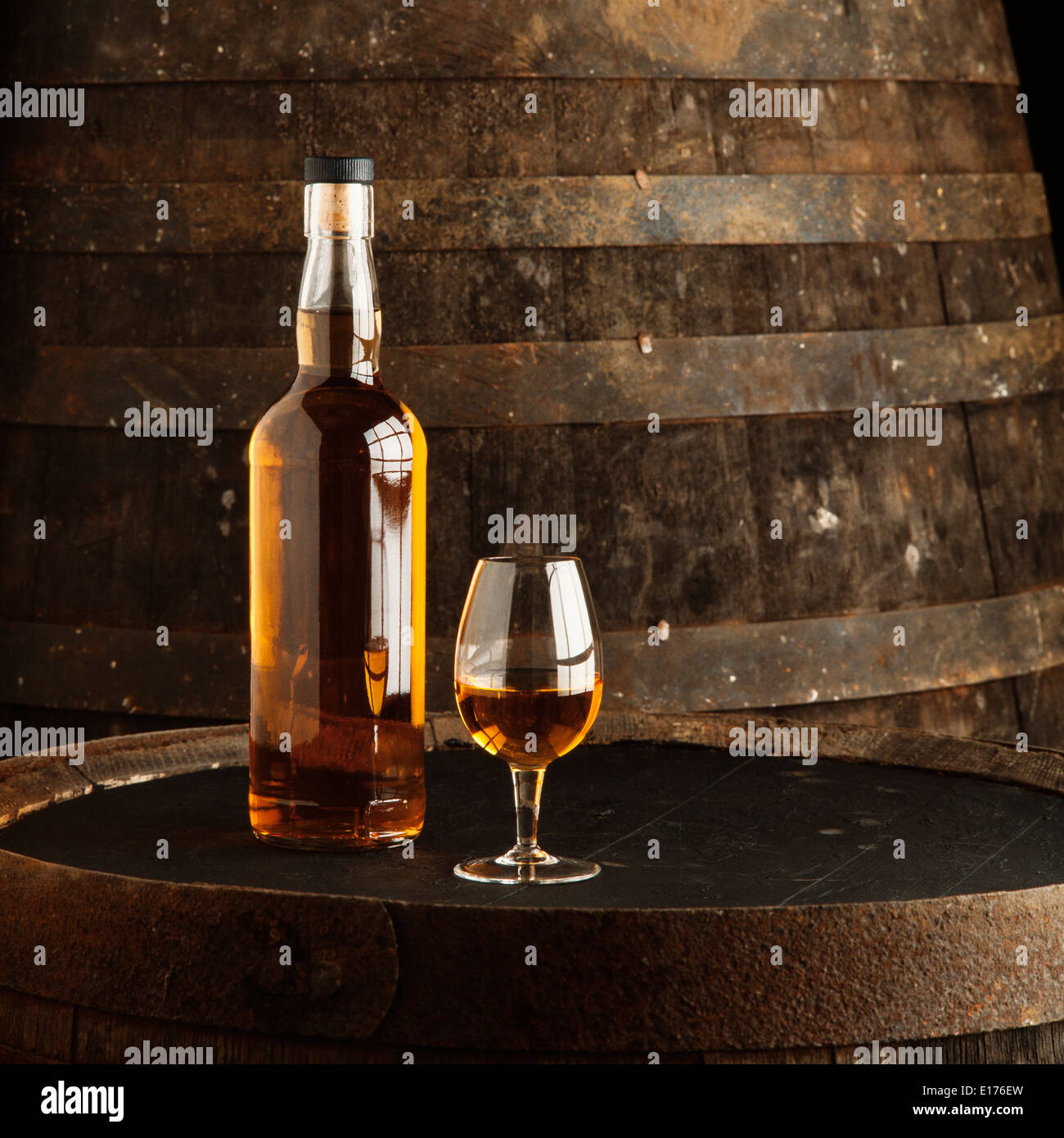 Ungekennzeichnete Whisky-Flasche und Glas auf Lauf Stockfoto