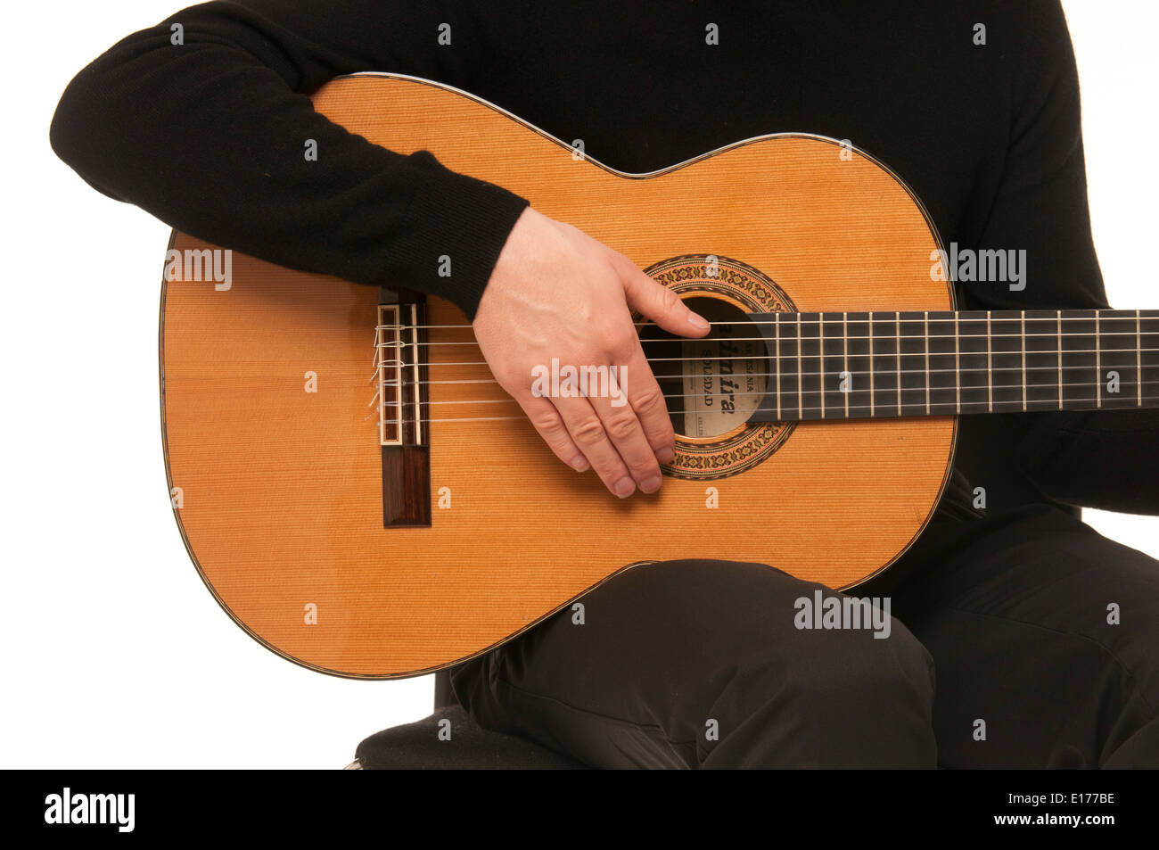 Nahaufnahme des männlichen Gitarristen zeigen, wie man mit einer klassischen akustischen Gitarre klimpern Stockfoto