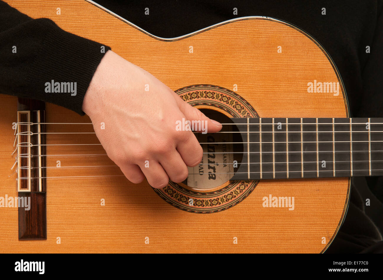 Nahaufnahme des männlichen Gitarristen zeigen, wie man mit einer klassischen akustischen Gitarre klimpern Stockfoto