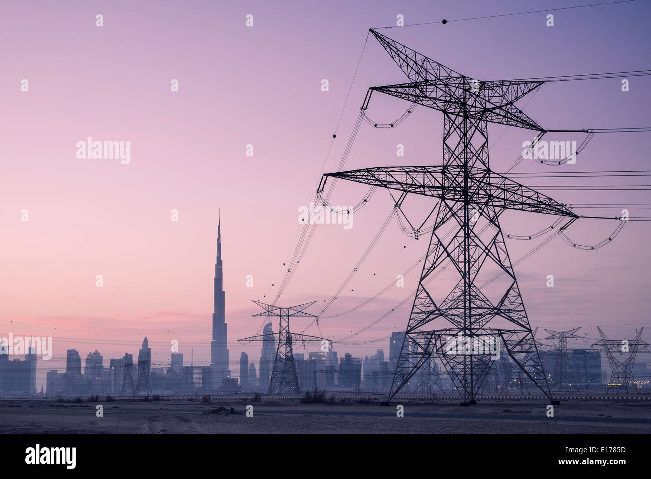 Stromleitungen und Pylonen und Skyline in der Abenddämmerung in Dubai Vereinigte Arabische Emirate Stockfoto