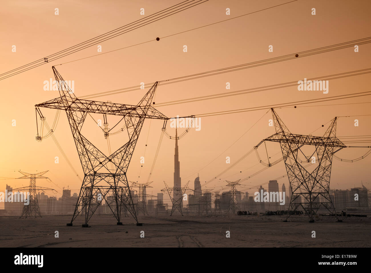Stromleitungen und Pylonen und Skyline in der Abenddämmerung in Dubai Vereinigte Arabische Emirate Stockfoto