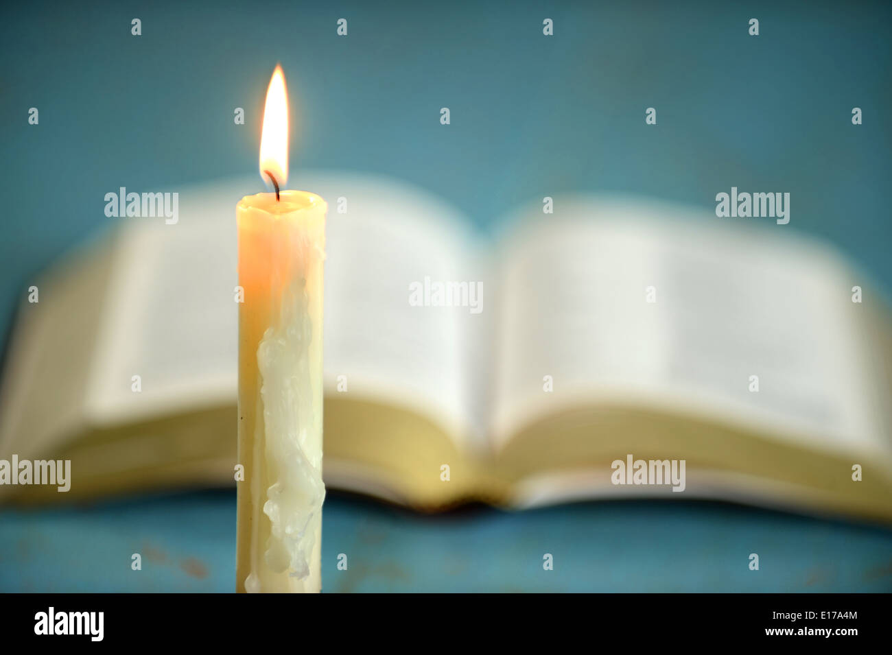 Wachskerze mit öffnen Sie Bibel im Hintergrund - mit geringen Schärfentiefe Stockfoto