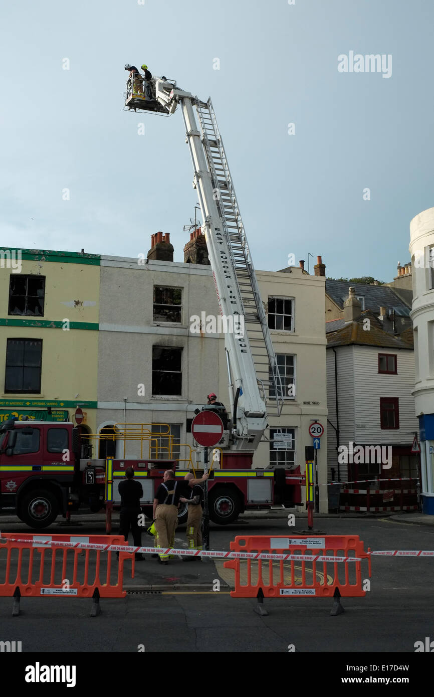 Hastings Marine Parade, Feuerwehrleute untersuchen ausgebrannte Hülle der Terrasse Häuser entkernt durch einen Brand am 25. Mai 2014 Stockfoto