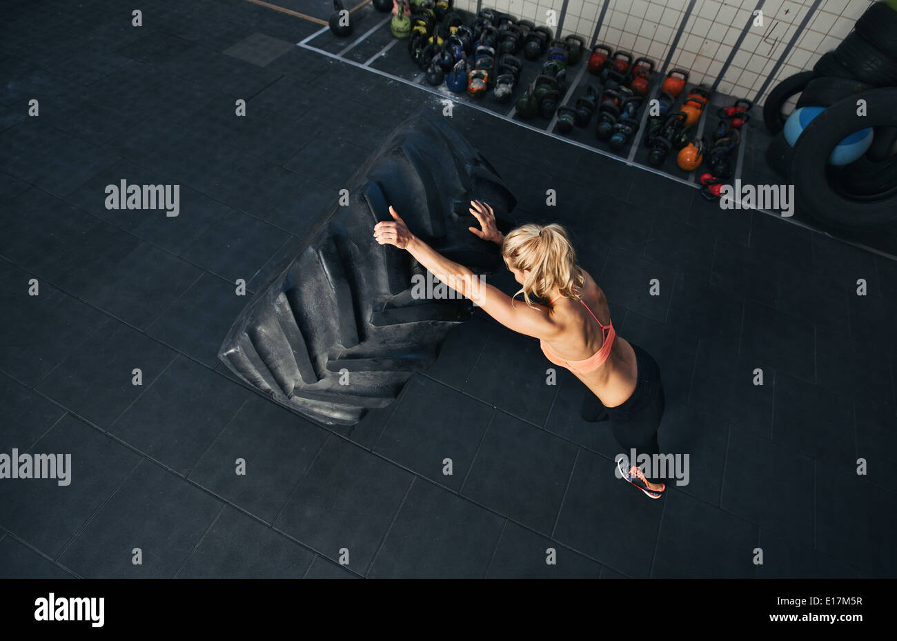 CrossFit Frau im Fitness-Studio trainieren. Muskulöse Frauen spiegeln sehr großer Gummireifen Stockfoto