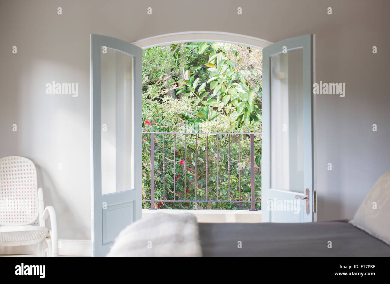 Fenstertüren öffnen sich zum Balkon in Luxus Schlafzimmer Stockfoto