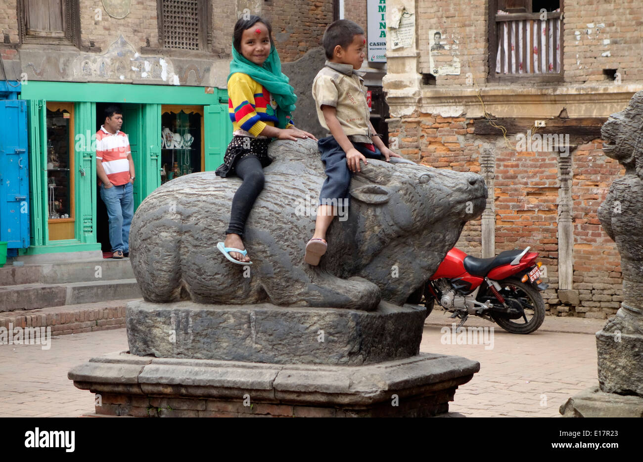 Kinder, Nepal, Asien, offene Straße, Szenen-Fotos, kalt, süß, Fotografie, Kinder spielen auf der Statue. Stockfoto