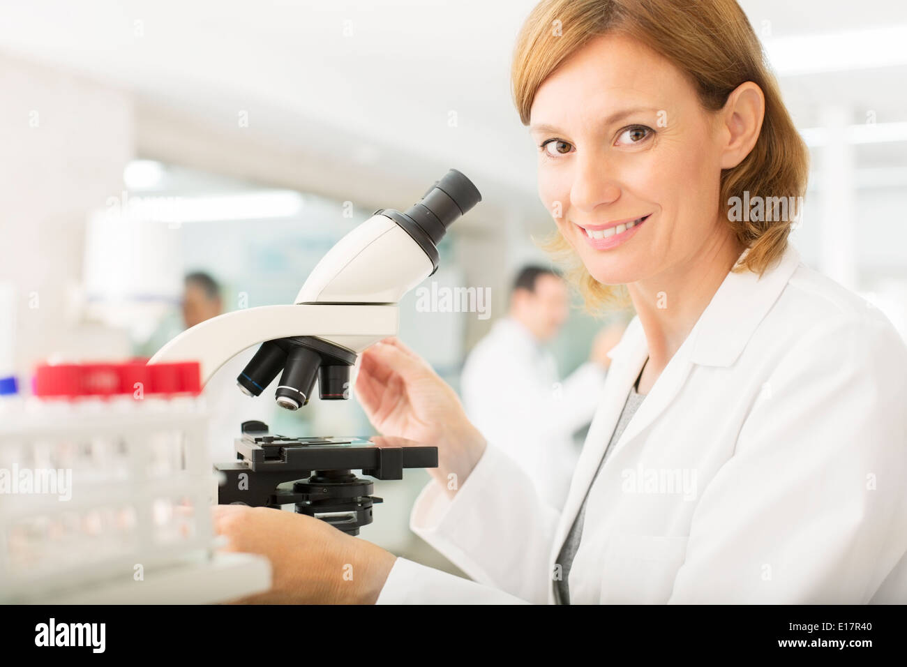 Porträt von zuversichtlich Wissenschaftler Mikroskop im Labor Stockfoto