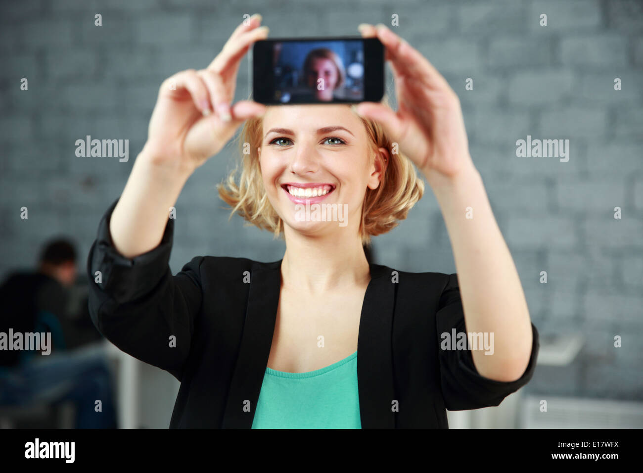Glückliche Mädchen, ein selbst Foto von ihrem Smartphone im Büro Stockfoto