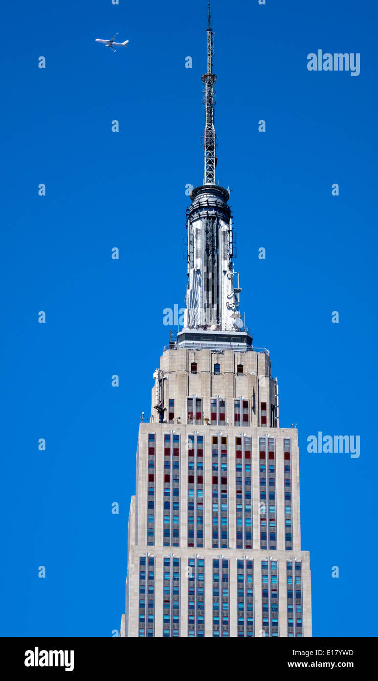 Turm auf dem Empire State Building in New York City mit ein Düsenflugzeug vorbei über Kopf Stockfoto