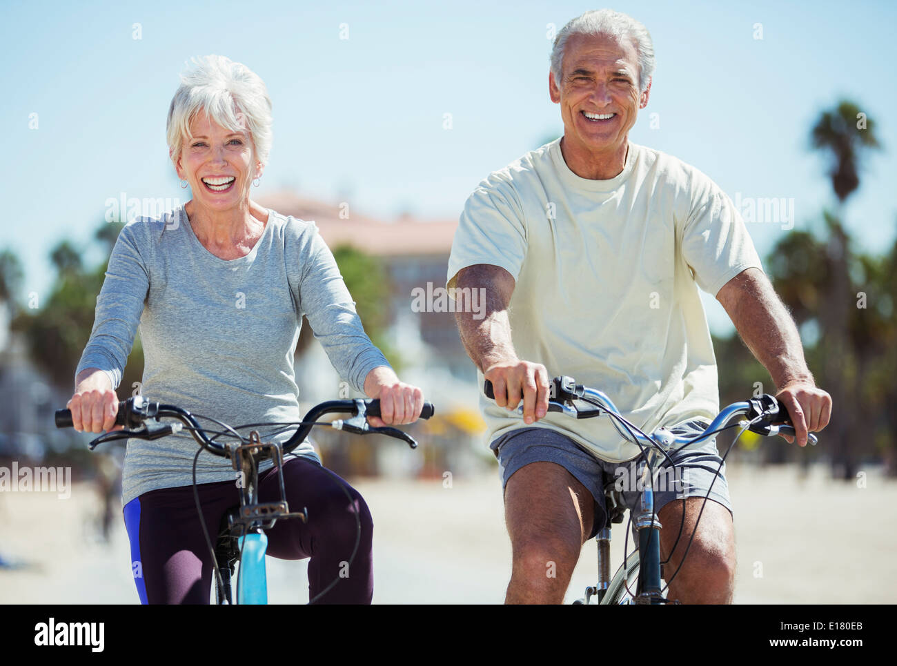 Porträt von älteres paar Fahrrad am Strand Stockfoto