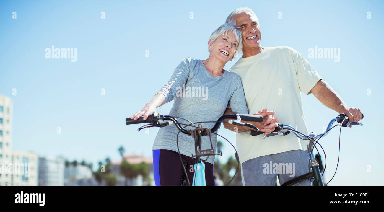 Älteres Paar mit Fahrrädern am Strand Stockfoto