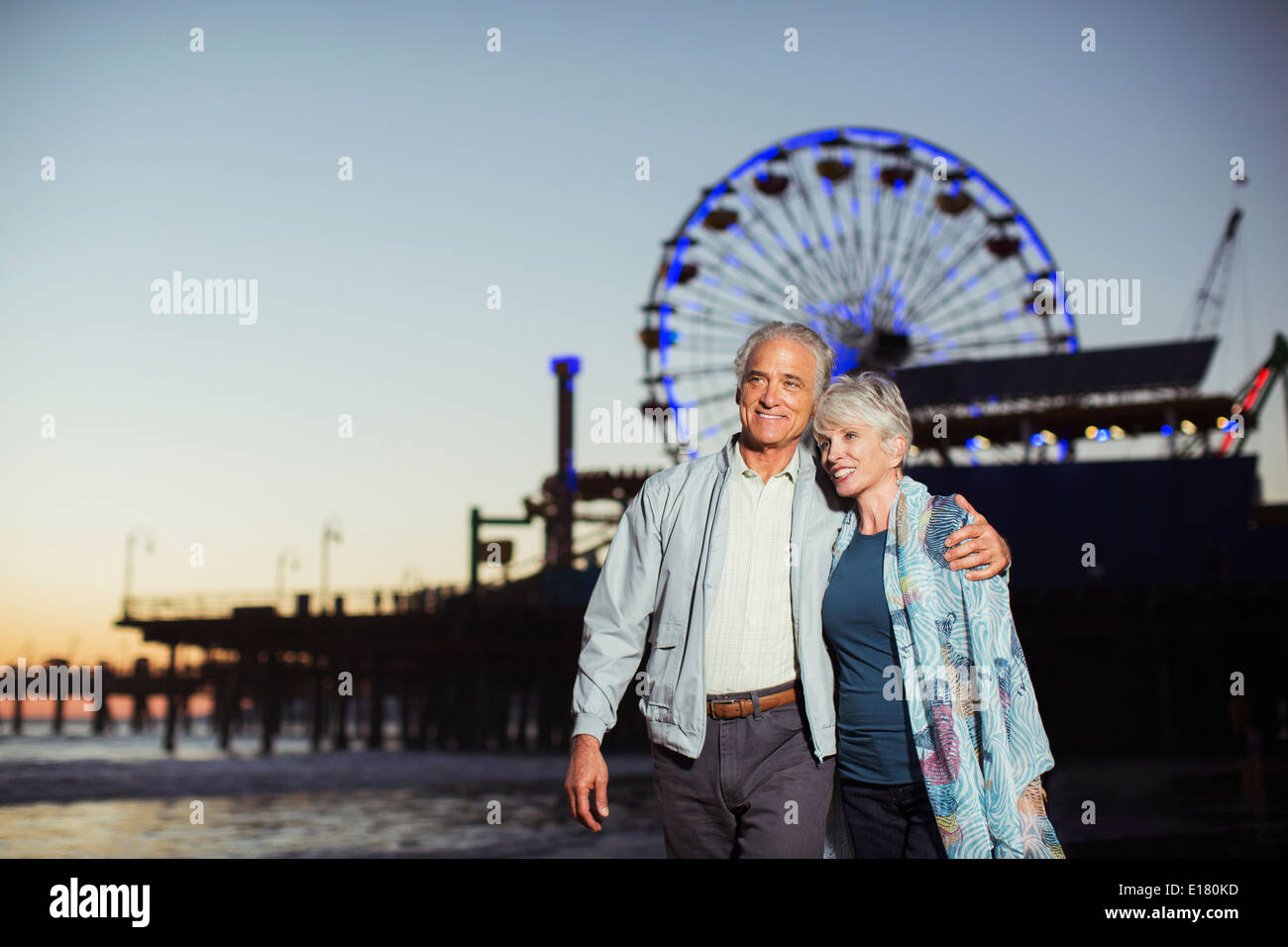 Älteres Paar zu Fuß am Strand bei Nacht Stockfoto