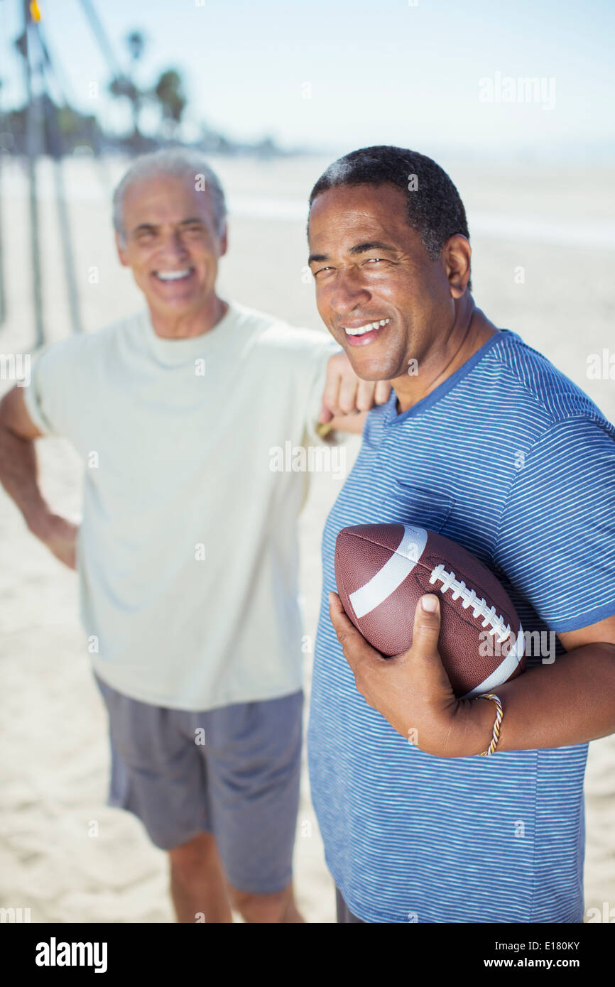 Ältere Männer mit Fußball am Strand Stockfoto