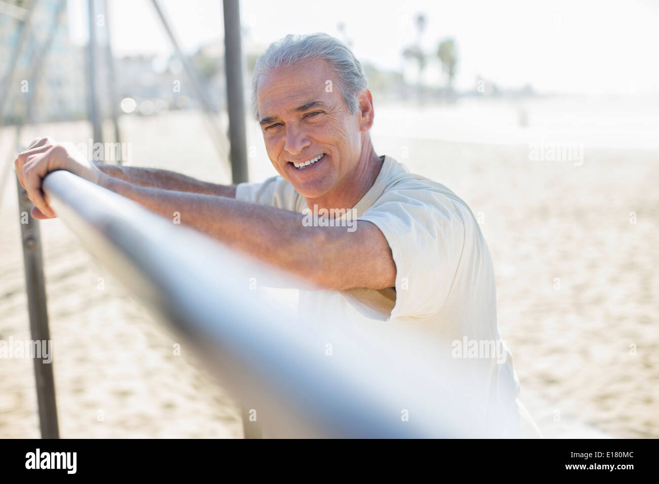 Portrait von senior Mann gelehnt auf Bar am Strand Stockfoto