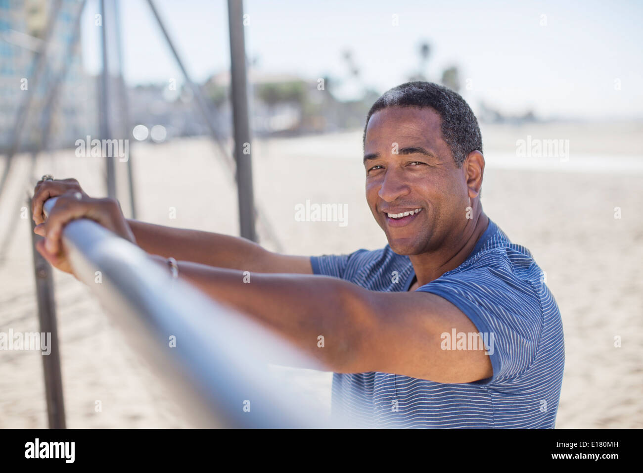 Portrait von senior Mann gelehnt auf Bar am Strand Spielplatz Stockfoto