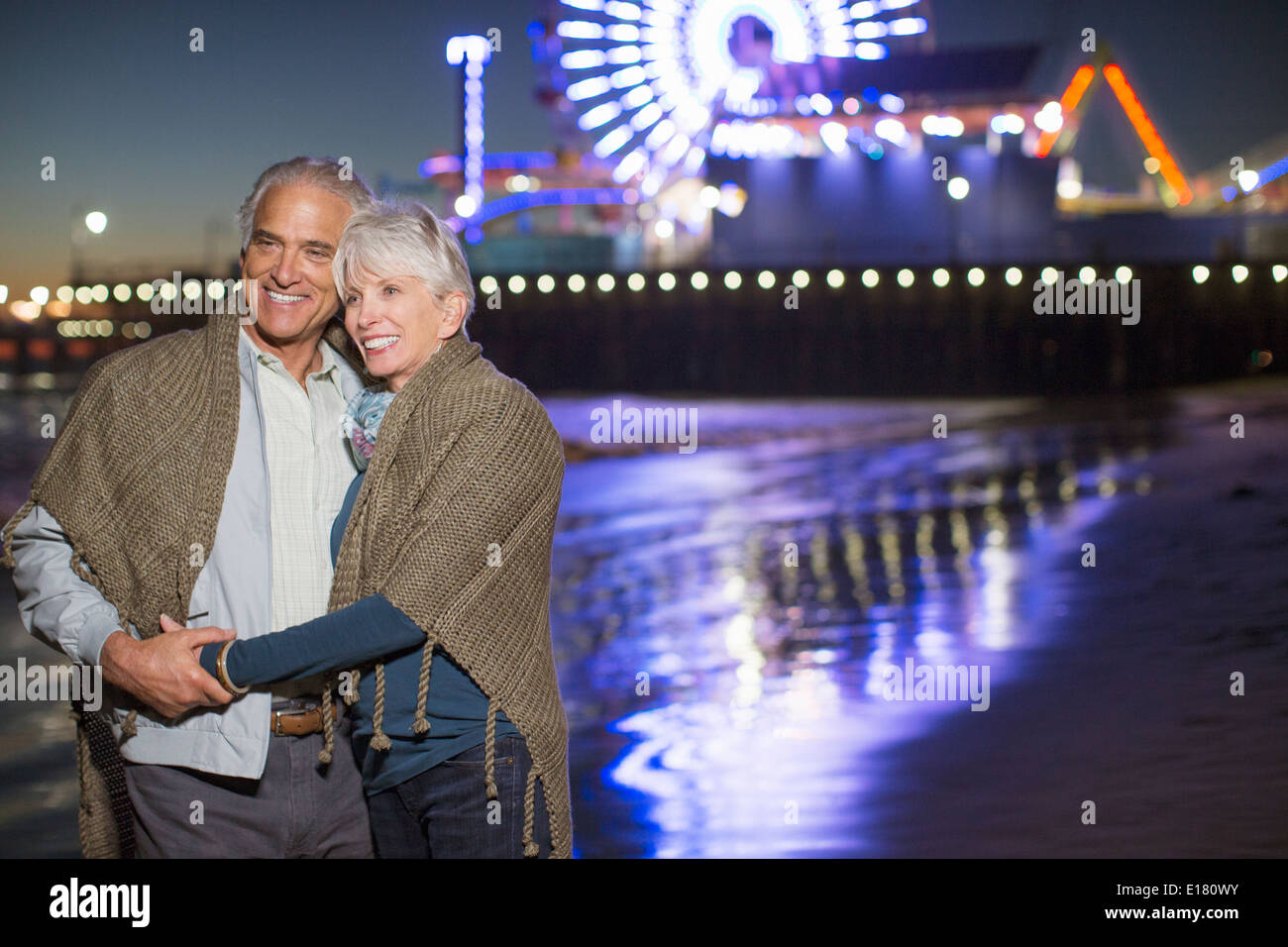 Älteres paar umarmt am Strand in der Nacht Stockfoto