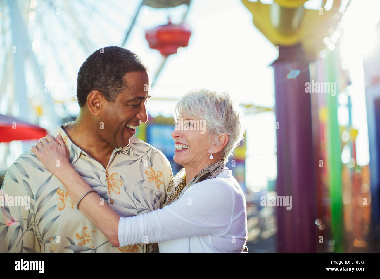 Älteres paar umarmt im Freizeitpark Stockfoto