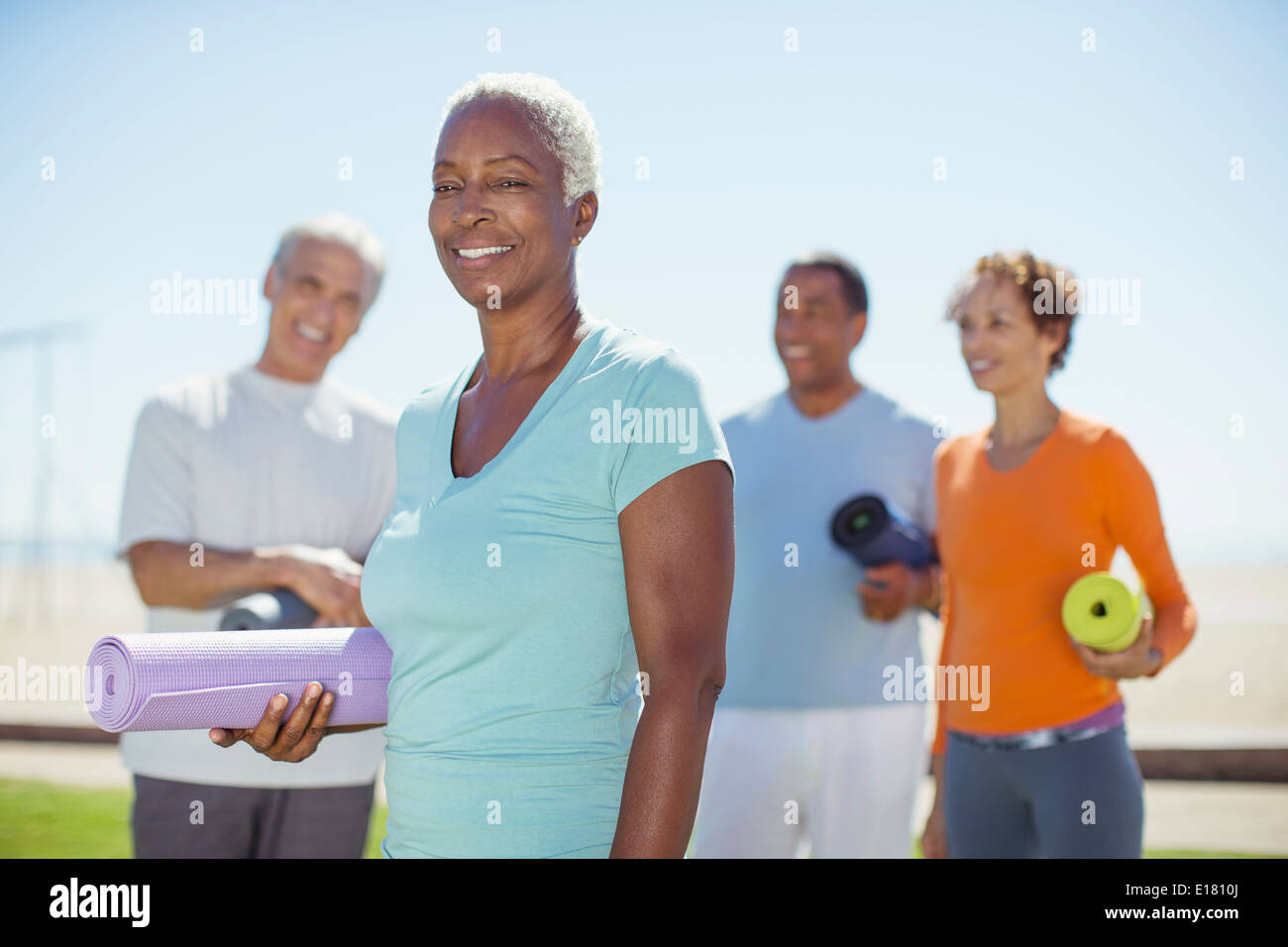 Porträt der selbstbewusste ältere Frau mit Yoga-Matte im park Stockfoto