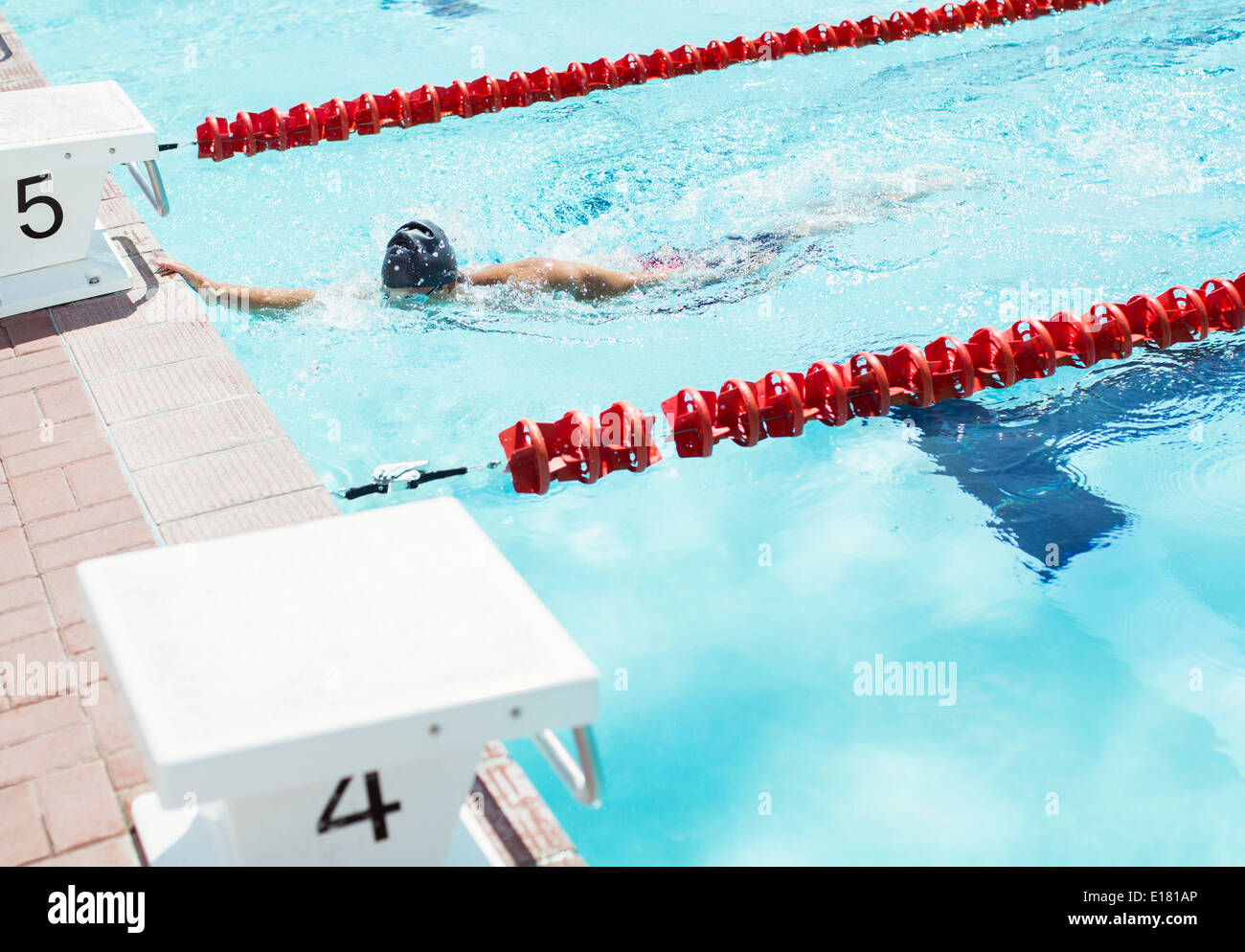 Schwimmer, die Kante des Pools berührt Stockfoto