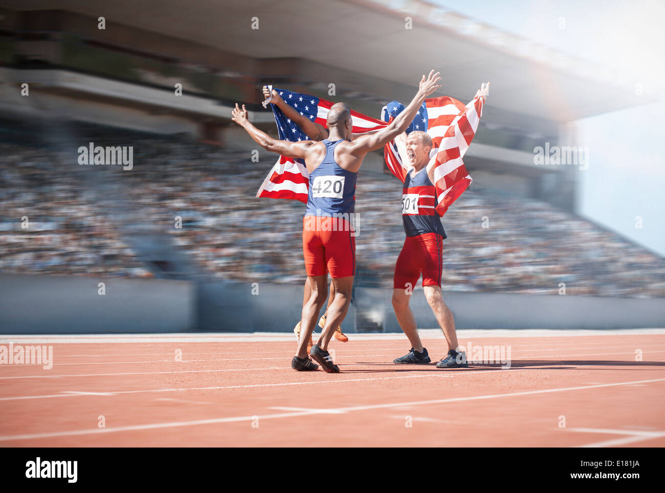 Läufer feiern und amerikanische Flaggen auf Kurs halten Stockfoto