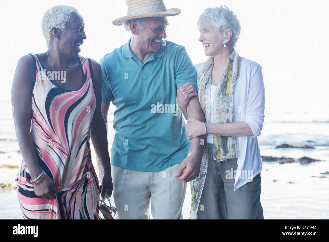 Senioren Freunde zu Fuß am Strand Stockfoto
