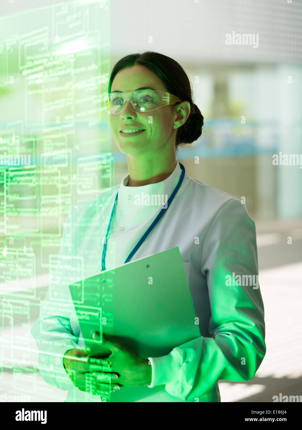 Lächelnde Arzt mit Zwischenablage im Krankenhaus Stockfoto