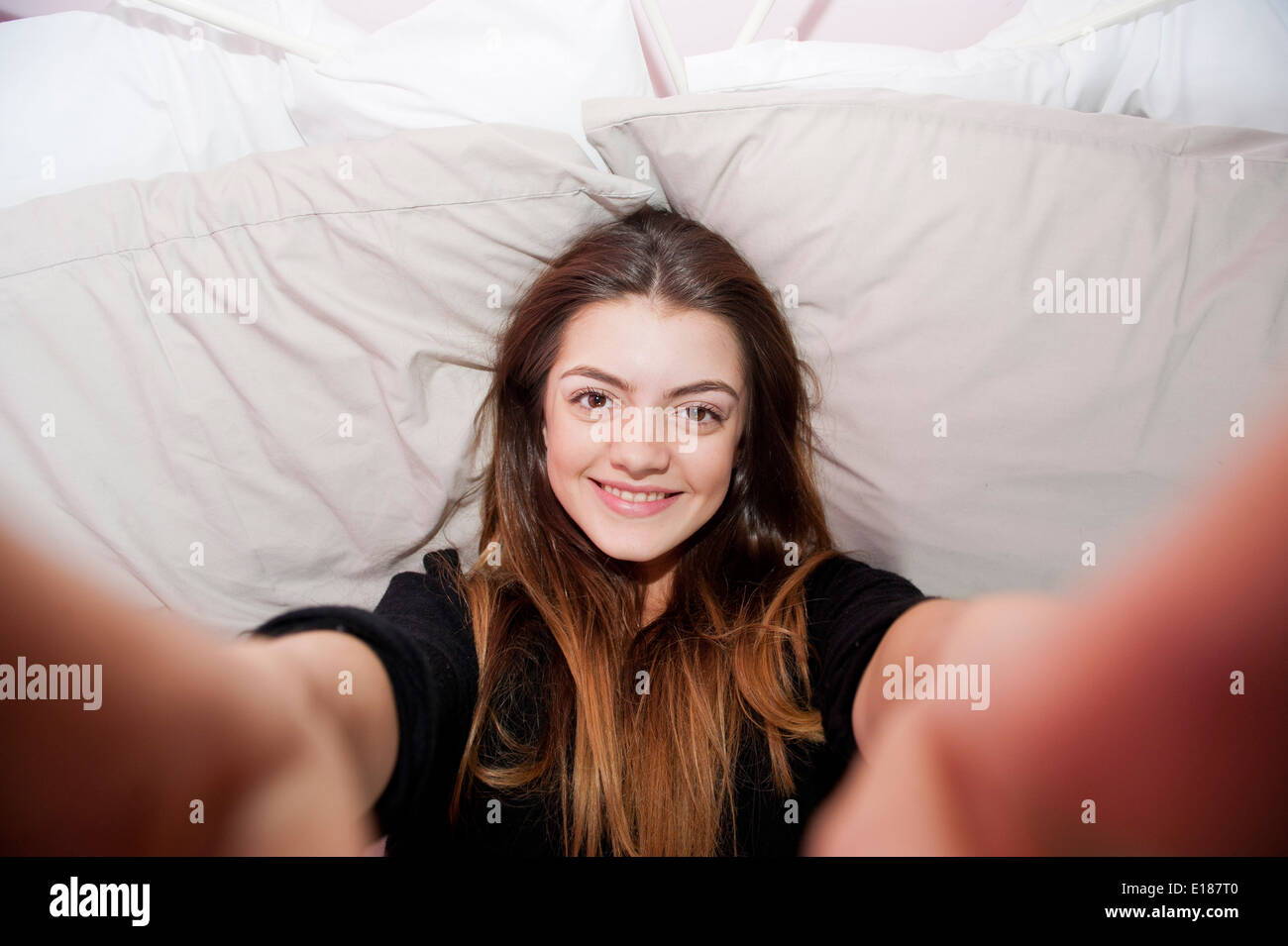 13 Jahre alten Mädchens posieren für ein vorgeben Selfie in ihrem Schlafzimmer Stockfoto