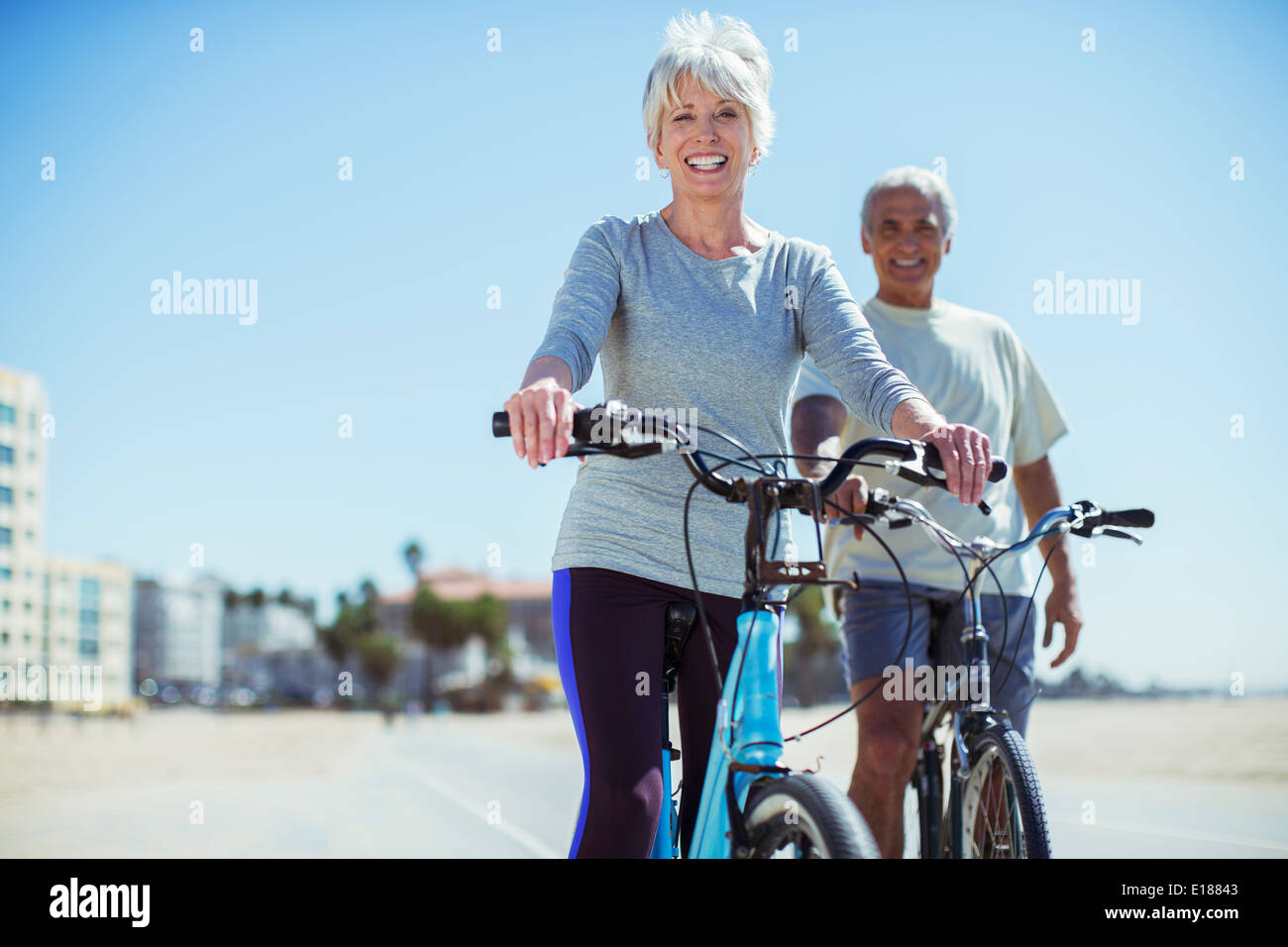 Porträt von älteres Paar mit Fahrrädern auf der Strandpromenade Stockfoto