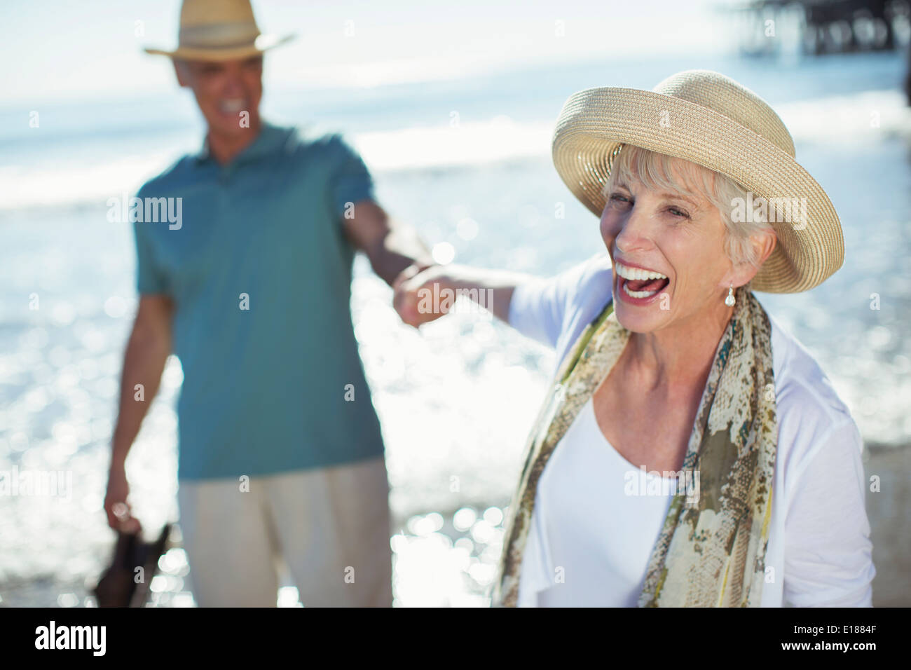 Begeisterte älteres Paar halten Hände am Sonnenstrand Stockfoto