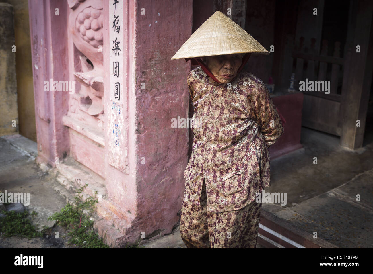 Eine ältere Frau, die der japanischen Brücke bedeckt mit Non La, die typische vietnamesische Hut Stockfoto