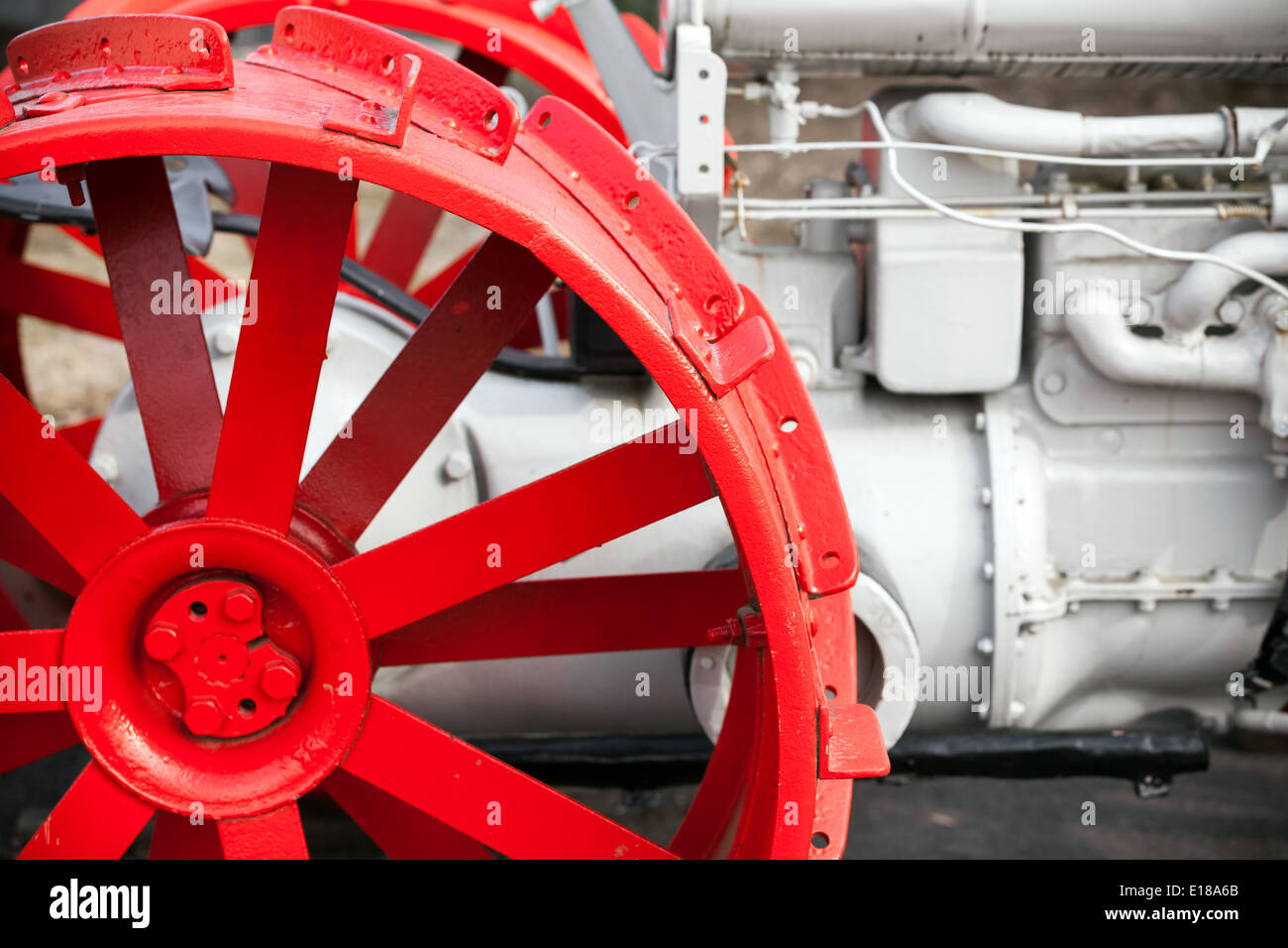 Fragment der alten weißen Traktor mit roten Rad Stockfoto