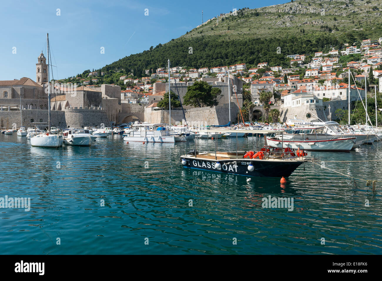 Blick über den Hafen mit Booten im Vordergrund und die Mauern der Altstadt im Hintergrund, Dubrovnik, Kroatien Stockfoto