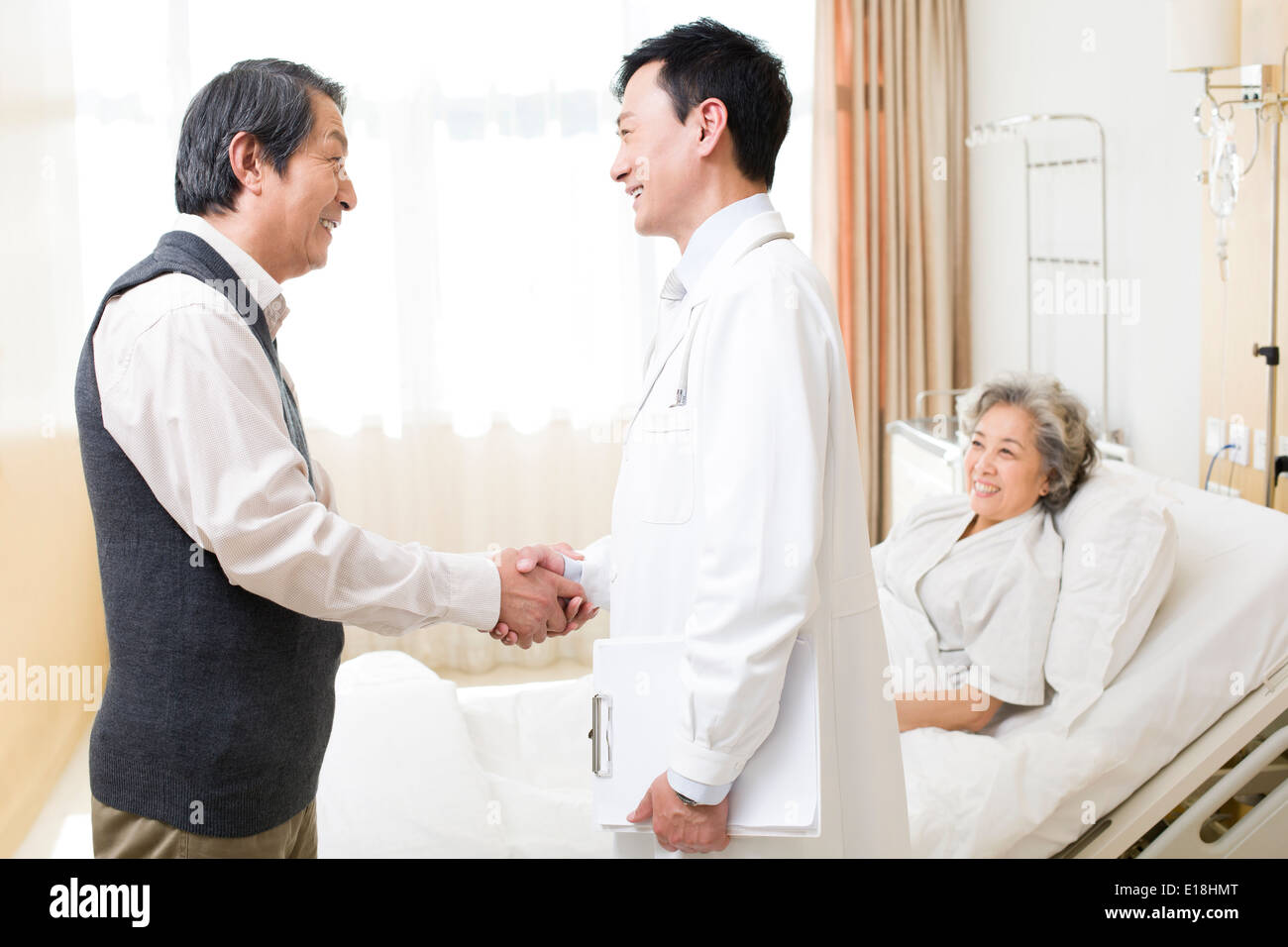 Älteres paar Händeschütteln mit Arzt im Krankenhaus Stockfoto